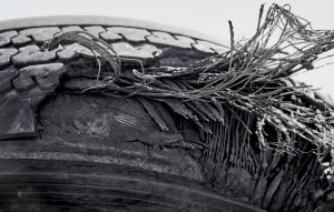Old tire with layers exposed showing the steel and fibre remnants that are used in tire construction